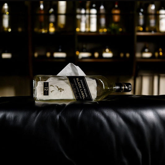 Bottle of Absolut Vodka on a black leather surface with blurred bar background